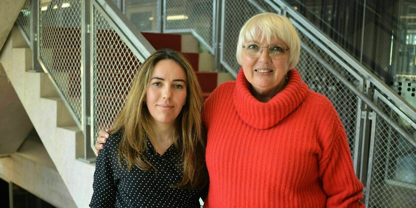 Stella Assange und Claudia Roth stehen im Treppenhaus der taz