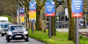 Eine Straße mit Autos und Wahlplakaten von Bürgern in Wut und anderen Parteien in Bremen