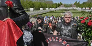 Viele Menschen mit Nelken und Bannern mit russischsprachingen Botschaften: die sogenannten Nachtwölfe in Berlin am Ehrenmal im Treptower Park am Tag der Befreiung im Jahr 2021