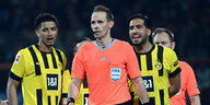 Schiedsrichter Stegemann im Vordergrund, dahinter protestierende Dortmunder Spieler