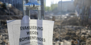 Ein Hinweiszettel an einem Bauzaun, Aufschrift: Evakuierung wegen Bombenfundes