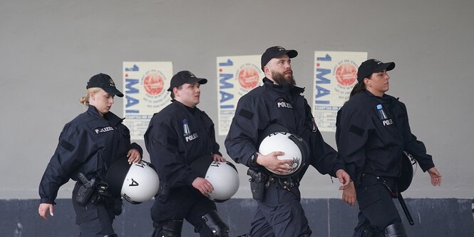 Polizeibeamte gehen vor den Teilnehmerinnen und Teilnehmer der revolutionären 1. Mai-Demo «Kampf auf der Straße, Streik im Betrieb. Das ist unsere Antwort auf Eure Politik» auf einer Straße