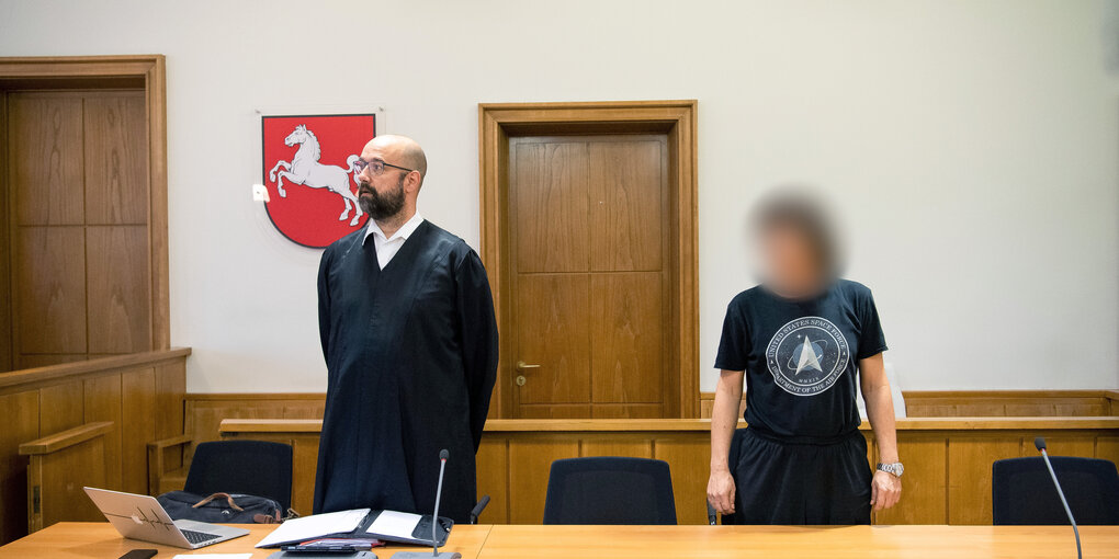 Der Angeklagte steht vor Prozessbeginn mit seinem Anwalt Tobias Pohl im Gerichtssaal.