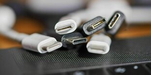 Verschiedene Ladekabel mit dem neuen EU Standard USB-C liegenauf einem Rechner