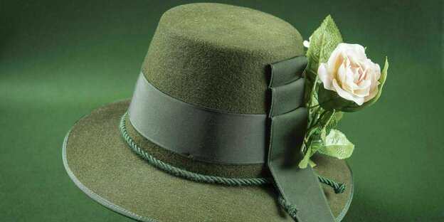Grüner Filzhut mit Hutband an dem eine Rose befestigt ist