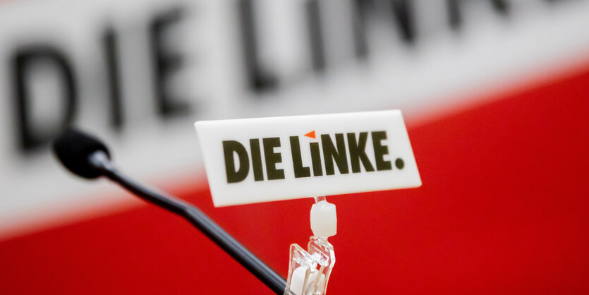 Logo der Partei die Linke an einem Mikrofon