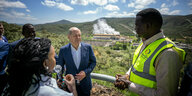 Kenia, Olkaria: Bundeskanzler Olaf Scholz, besucht die größte Geothermie-Anlage Afrikas in Olkaria am Naivsha-See. Er steht zusammen mit Davies Chirchir, Minister für Energie in Kenia, vor einer Landschaft.