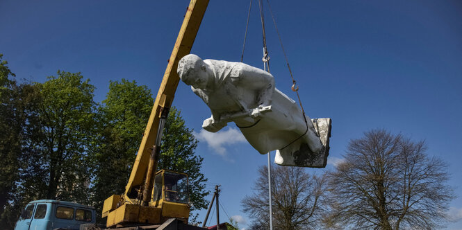 Eine Soldatenstatue hängt an einem Kran