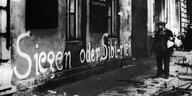 Eine Durchhalte-Parole der Nazi-Propaganda " Siegen oder Sibirien " an einer Hauswand in Berlin Anfang 1945.