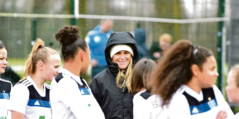 Catharina Schimpf steht inmitten von HSV-Spielerinnen.