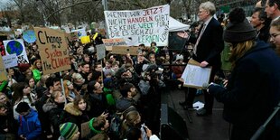 Mann vor protestierender Menschnmenge