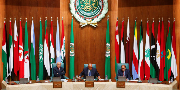 Drei Männer sitzen auf einem Podoium vor ihren Labtops - hinter ihnen die Fahnen der Länder, die zur arabischen Liga gehören