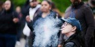 Eine Person raucht einen Joint in der Öffentlichkeit