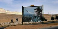 Eine Werbetafel mit dem martialischen Bild von Bashar al-Assad mit Sonnenbrille in Uniform, hinter ihm bewaffnete soldaten und Raketen, die in den Himmel steigen