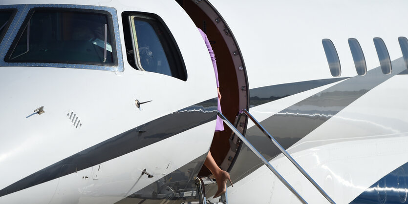 Eine Frau verschwindet gerade in einem mittelgroßen Flugzeug