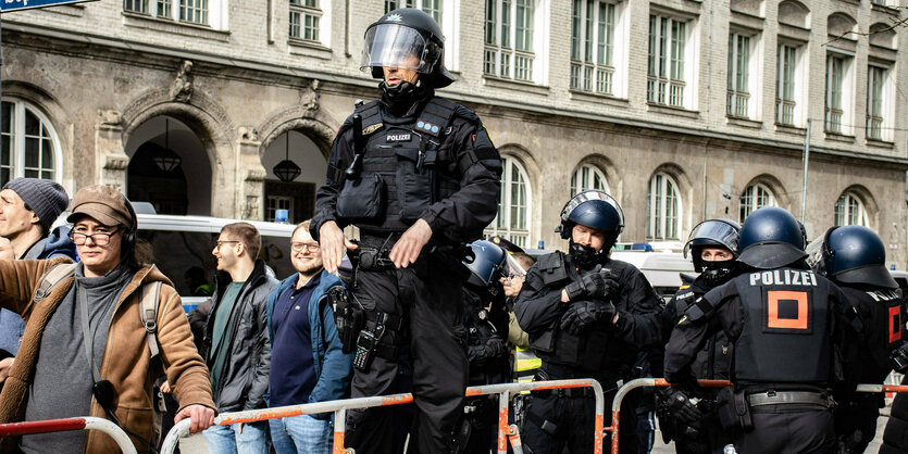 Ein Polizistin erhöhter Position auf einer Absperrung