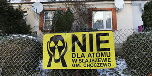 gelbes anti-atomplakat am Zaun vor einem alten Haus
