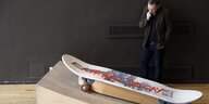 Mann betrachtet Skateboard