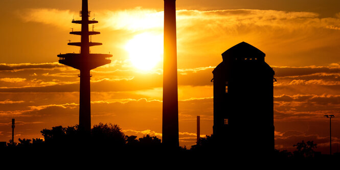 Die strahlende Abendsonne geht hinter den Türmen am Kulturzentrum Schlachthof und dem Bremer Fernsehturm unter