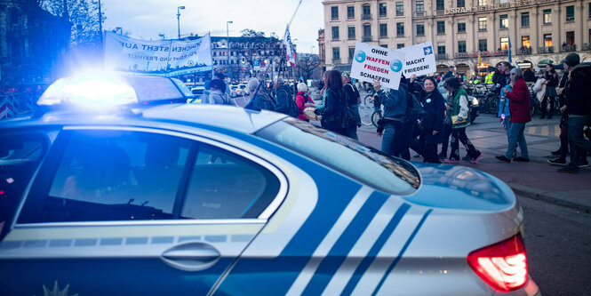 Ein Polizeifahrzeug vor Demonstranten