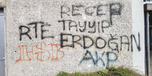 Auf einer Wand steht in schwarzen Graffiti-Buchstaben "Recep Tayyip Erdoğan" und in blau "AKP"