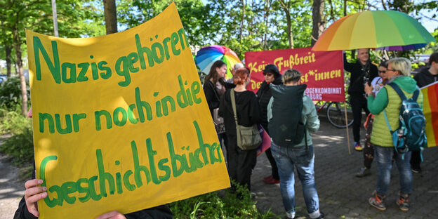 Ein Teilnehmer der Demonstration «Vielfalt statt Einfalt - Schule ohne Diskriminierung» steht mit einem Schild mit der Aufschrift «Nazis gehören nur noch in die Geschichtsbücher» vor dem Schulamt in Cottbus.