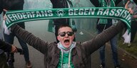 Ein BremenFan hält einen Schal hoch. darau fsteht "Werderfans gegen Rassismus"