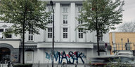 Weiße Fassade mit Säulen und Graffiti
