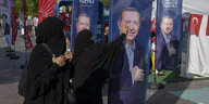 Frauen berühren ein Plakat von Erdogan