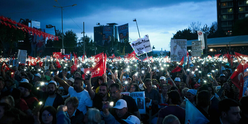 Eine Menschenmenge, in der die Lichter vieler Smartphones aufleuchten