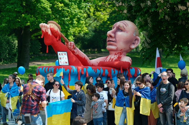 Demonstranten mit einer Karnevalsfigur vom russischen Präsidenten Putin in einem Blutbad aus dem Rosenmontagszug in Düsseldorf