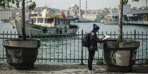 ein Mann liest eine Zeitung vor der Kulisse Istanbuls