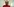 Cisse lacht sehr breit , sie trägt einen roten Pullover und eine hellbraune Kopfbedeckung