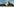 Kubanischer Häuserblock vor blauem Himmel mit monumentalem Che-Guevara-Fresko.