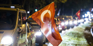 Eine türkische Flagge wird aus einem Autofenster gehängt im Stau
