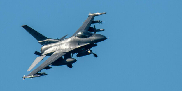 Kampfjet vom Typ F-16 im Landeanflug mit ausgefahrenem Fahrwerk.