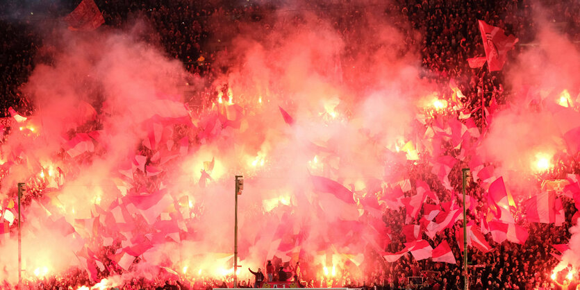 Fanblock mit Pyrotechnik und Fans mit Flaggen