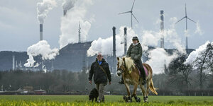 Mann und Reiterin mitr Pferd vor BP-Raffinerie in Gelsenkirchen