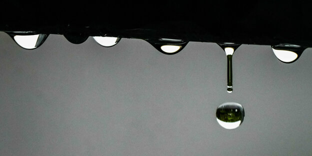 Wasser tropft während eines der zahlreichen Regenschauer von einem Geländer
