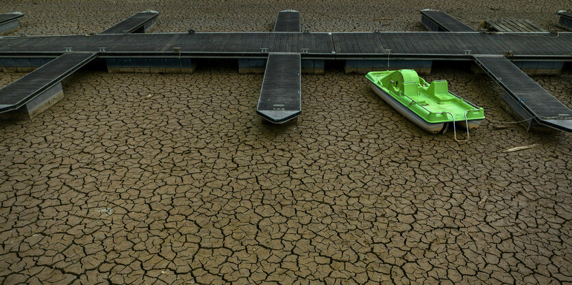 Eine Anlegestelle im Sau-Stausee hat kein Wasser mehr, ein Tretboot liegt auf dem Trockenen