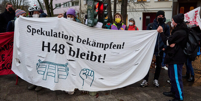 Protestierende halten einen Banner hoch, darauf steht 