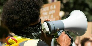 Ein Demonstrant mit Megaphone im Demozug