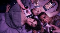 Drei Personen liegen, vier Smartphones über ihren Körpern zeigen erotische Bilder