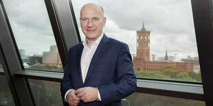 Kai Wegner vor der Skyline von berlin, mit dem roten Rathaus