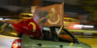 Türkische Fahne mit Erdogans Gesicht wird aus einem offenen Autofenster gehalten