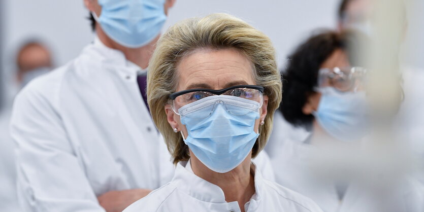 Ursula von der Leyen trägt einen weißen Kittel und eine blaue Gesichtsmaske