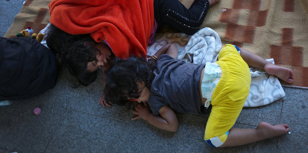 Flüchtlingskinder schlafen auf dem Boden vor dem Ostbahnhof in Budapest