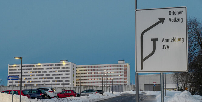 Gebäude und daneben ein Straßenschild (Wegweiser)