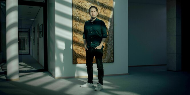 Kevin Kuehnert steht vor einem Gemälde