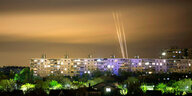 Racketenfeuer beleuchtet den Himmel über Hochhäusern in Charkiv